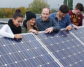 Öko-Aktivist Knechten (m.) klärt über die Schmutz und Nässe abweisende Oberflächenstruktur der Solarpanels auf