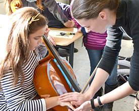 Musikreferendarin Ortrun Peters widmet sich der Bogenhaltung einer Fünftklässlerin am Cello