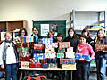 Schülerinnen und Schüler der Klassen 8a und 6d präsentieren die von ihnen zusammengestellten Weihnachtspakete