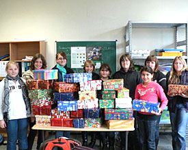 Schülerinnen und Schüler der Klassen 8a und 6d präsentieren die von ihnen zusammengestellten Weihnachtspakete