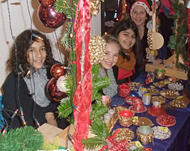 Layla, Isabella, Niga und Jil aus der Klasse 6a bieten an ihrem Stand traditionelle Weihnachtsartikel an 